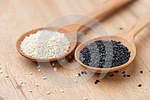 Close up of black sesame and white sesame seed on wooden spoon in kitchen