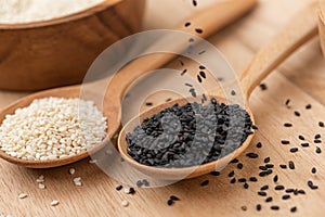 Close up of black sesame and white sesame seed on wooden spoon in kitchen