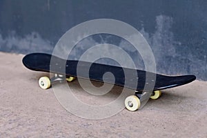 Close up black skateboard on city street urban background