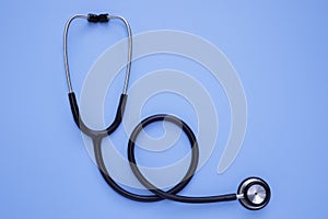 Close-up of Black stethoscope of doctor for checkup on blue background. Stethoscope equipment of medical use to diagnose from hear