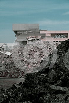 Close-up of a black stone with a semi-detached industrial building in the background photo