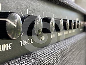 Close-up black treble knob volume on the control panel of the boutique electric guitar amplifier. clean and hi-gain distortion.