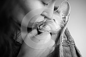 Close up, black and white photo of a woman kissing cute Devon Rex cat, love and tender mood image