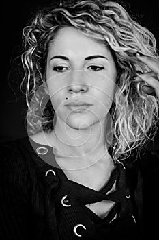 Close up black and white portrait of a beautiful young woman with blonde and curly hair