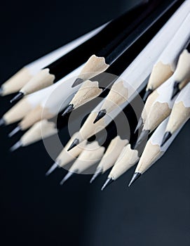 Close up of black and white wooden pencil tips with blurred perspective.