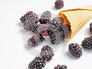 Close up Blackberry in a waffle cone on a white table. Still life berries