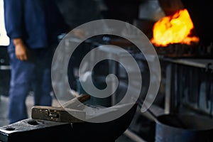 Close up of blacksmith heating metal piece at forge