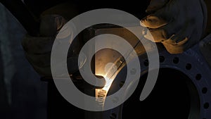 Close up of blacksmith welder in protective uniform works with metal steel and iron using a welding machine. Creative