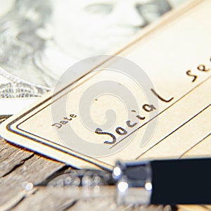 Close up blank with description: Social security and US Dollar bill. Money in retirement concept. Selective focus