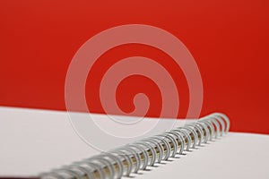 Close-up blank notebook with white papers and white springs.