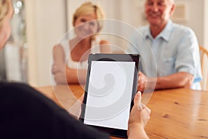 Close Up On Blank Screen Of Digital Tablet As Retired Couple Meeting With Financial Advisor At Home