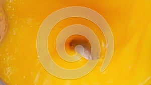 Close up of blended tropical mango in a blender, top view. Sweet mango fruit with milk blended up to the healthy mango smoothie. H