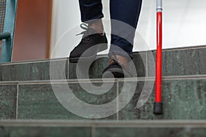 close up blind person negotiating steps using cane