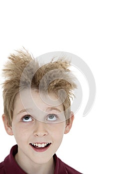 Close-up of blond boy looking up over white background