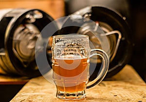 Close up of a blonde craft beer filled into a pint glass on wooden table