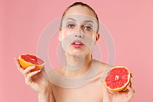 Close up blonde half naked woman 20s perfect skin nude make up blue eyes hold in hand grapefruit isolated on pastel pink