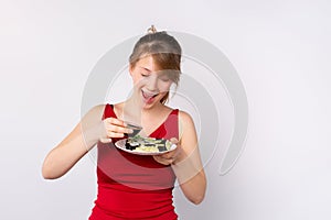 Close up of blonde woman holding bowl with soy sauce and plate with vegetarian sushi roll on white background, japanese