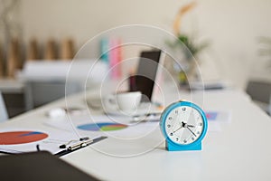Close up blue alarm clock on desk in modern office