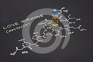 Close-up blue cap sample vial on paper with chemical formula of