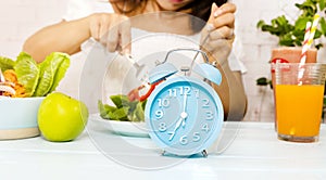 Close up of Blue clock  and Intermittent fasting program for diet plan which young woman Eating healthy breakfast bowl-Clean