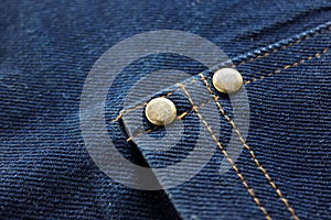 Close-up Blue Denim or jeans and metal buttons surface and texture background.