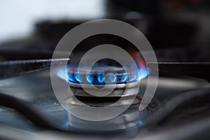 In this close up a blue gas flame from a gas burner is seen in a kitchen. Due to Russia`s invasion of Ukraine gas prices have