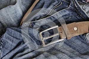 Close-up of blue jeans with a brown leather belt