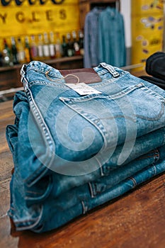 Close up of blue jeans pants stacks over counter on vintage clothes shop