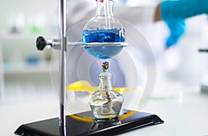 Close up of blue medical chemicals sample boiled in glass experiment at lab