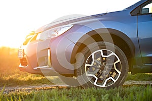 Close up of blue off road car on green grass. Traveling by auto, adventure in wildlife, expedition or extreme travel on a SUV