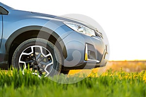 Close up of blue off road car on green grass. Traveling by auto, adventure in wildlife, expedition or extreme travel on a SUV