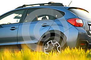 Close up of blue off road car on green grass. Traveling by auto, adventure in wildlife, expedition or extreme travel on a SUV