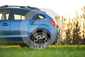 Close up of blue off road car on green grass. Traveling by auto, adventure in wildlife, expedition or extreme travel on a SUV