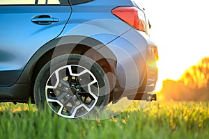 Close up of blue off road car on green grass. Traveling by auto, adventure in wildlife, expedition or extreme travel on a SUV