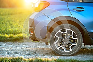 Close up of blue off road car wheel on gravel road. Traveling by auto, adventure in wildlife, expedition or extreme travel on a