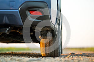 Close up of blue off road car wheel on gravel road. Traveling by auto, adventure in wildlife, expedition or extreme travel on a