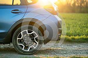 Close up of blue off road car wheel on gravel road. Traveling by auto, adventure in wildlife, expedition or extreme travel on a