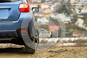 Close up of blue off road car wheel on gravel road. Traveling by auto on a SUV automobile. Offroad 4x4 vehicle detail