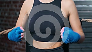 Close-up blue protective wrapped hand of kickboxer female hitting ready to mixed martial arts battle