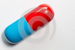 Close up of a blue and red pill isolated against a white background and free space for text