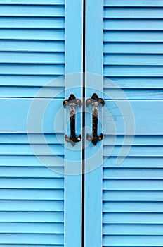 Close Up Blue Slatted Doors with Black Iron Handles - vertical