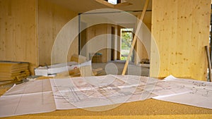 CLOSE UP: Blueprints and other plans lie on a makeshift desk in a CLT house.