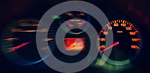 A Close up of the Blurred Illuminated Speedometer in Car