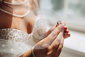 Close up of blurry woman& x27;s hand holding an elegant diamond ring.