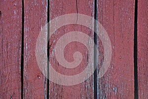 Close up of the boards of an old red  painted weathered barn for background  