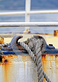 Close up of the boat bollard with a rope tied around