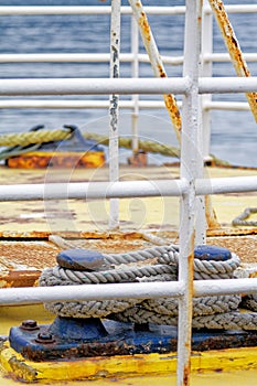 Close up of the boat bollard with a rope tied around