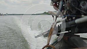 Close-up of the boat engine's long driveshaft working producing movement of the long-tail Thailand traditional boat