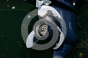 Close-up of boat propeller in water with algae