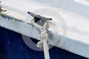 Close up of boat rope tied to nautical cleat hitch on boat